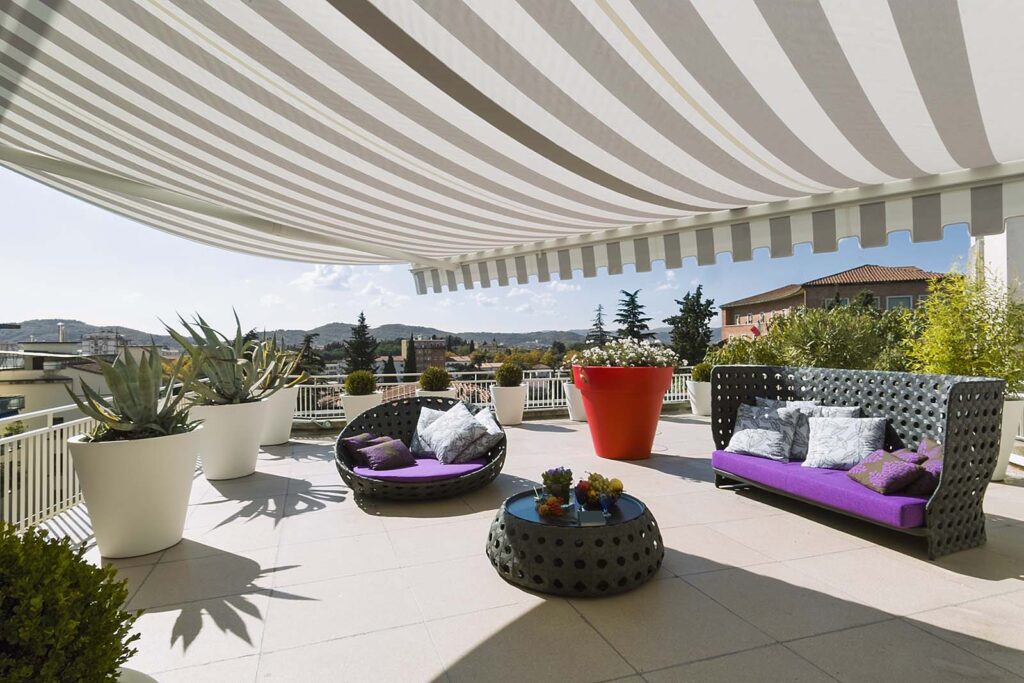 Exteriors shots of a modern terrace with awnings and contemporary sofas and armchairs